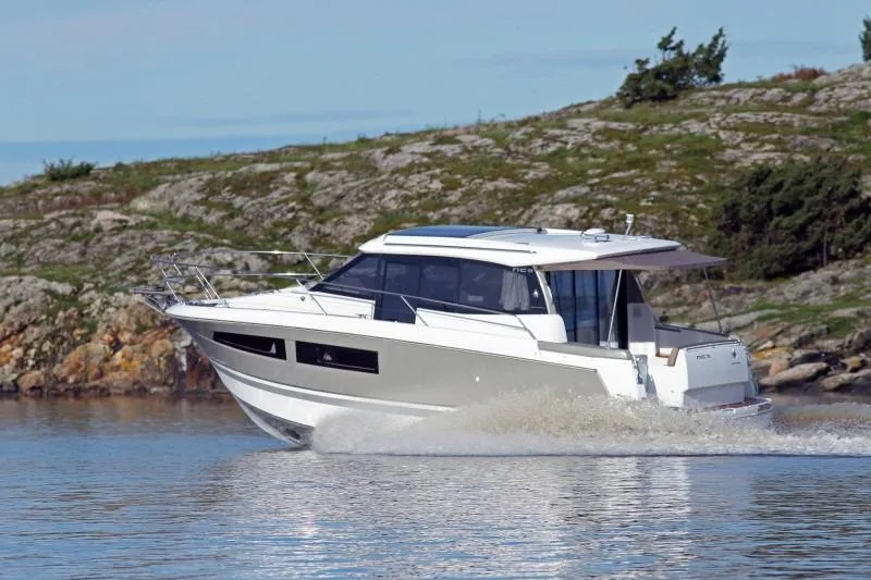  Yacht Photos Pics Manufacturer Provided Image: 2017 Jeanneau NC 9 motor yacht cruising near rocky shoreline.