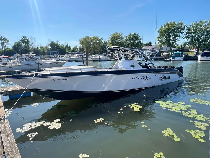  Yacht Photos Pics 2006 Donzi 38 ZFX boat docked in a marina, surrounded by water lilies.