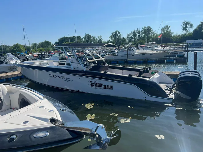  Yacht Photos Pics 2006 Donzi 38 ZFX boat docked in a marina on a sunny day.