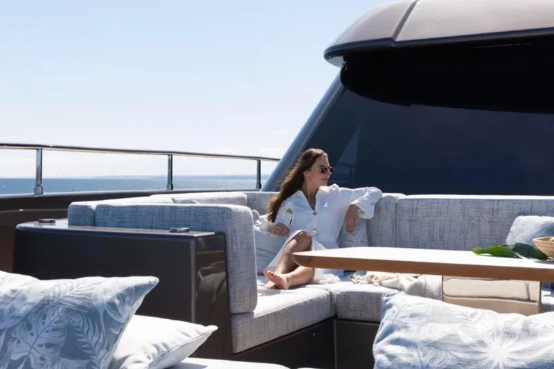 Twilight Yacht Photos Pics Woman relaxing on Sunreef 100 Power yacht, 2025 model, enjoying luxury outdoor seating.