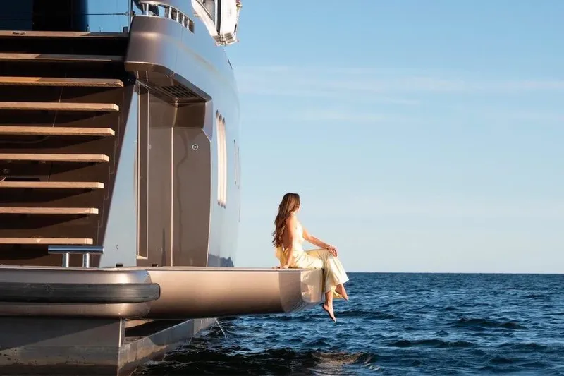 Twilight Yacht Photos Pics Woman relaxing on Sunreef 100 Power yacht, 2025 model, overlooking the ocean.