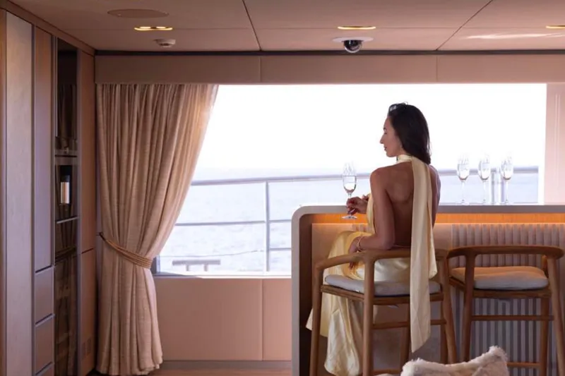 Twilight Yacht Photos Pics Elegant woman enjoying a drink on Sunreef 100 Power yacht, 2025 model, with ocean view.
