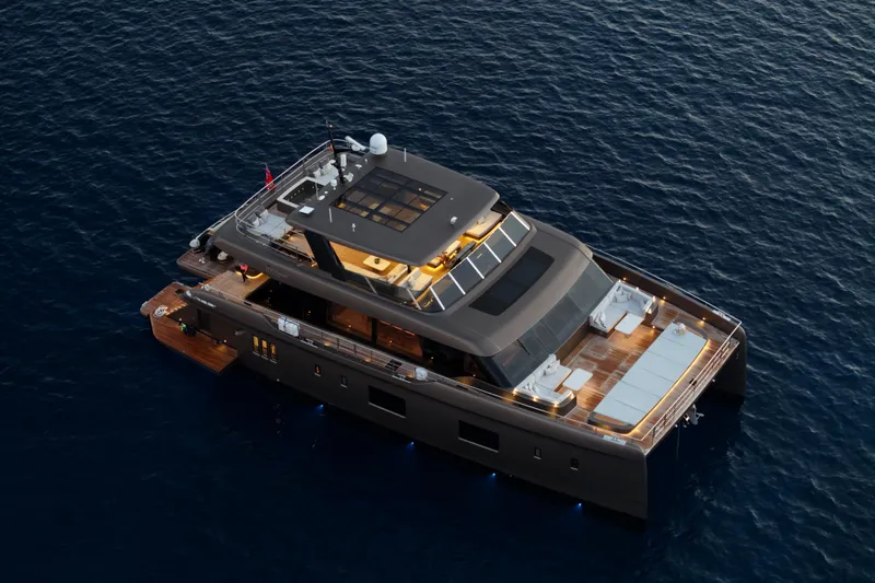 Twilight Yacht Photos Pics Luxurious 2025 Sunreef 100 Power yacht cruising on serene ocean waters at sunset.