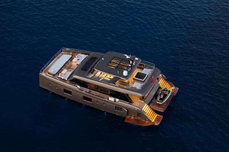 Twilight Yacht Photos Pics Luxurious 2025 Sunreef 100 Power yacht cruising on serene blue waters.