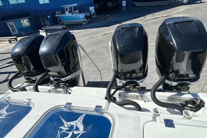  Yacht Photos Pics Four powerful outboard motors on a 2023 Freeman 42LR boat at a marina.