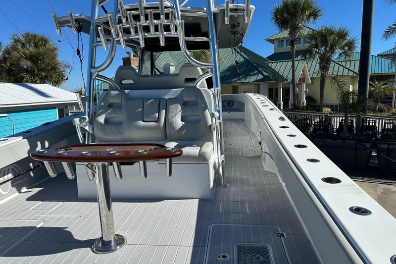  Yacht Photos Pics 2023 Freeman 42LR boat interior with seating and rod holders, docked near palm trees.