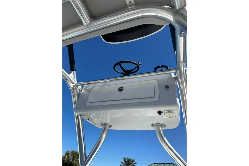  Yacht Photos Pics 2023 Freeman 42LR boat console with steering wheel, viewed from below against clear blue sky.