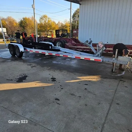  Yacht Photos Pics 2020 Ocean Scout 277 trailer parked on concrete, surrounded by equipment and trees.