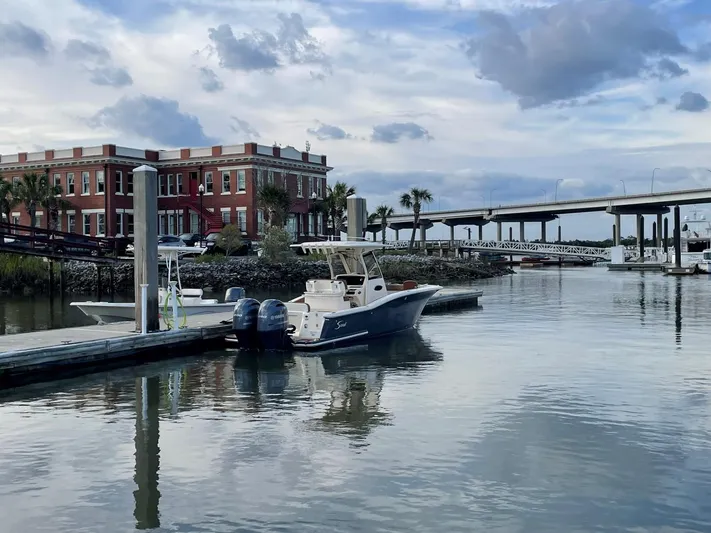  Yacht Photos Pics Ocean Scout 277 boat docked in scenic marina, 2020 model, with bridge and building in background.