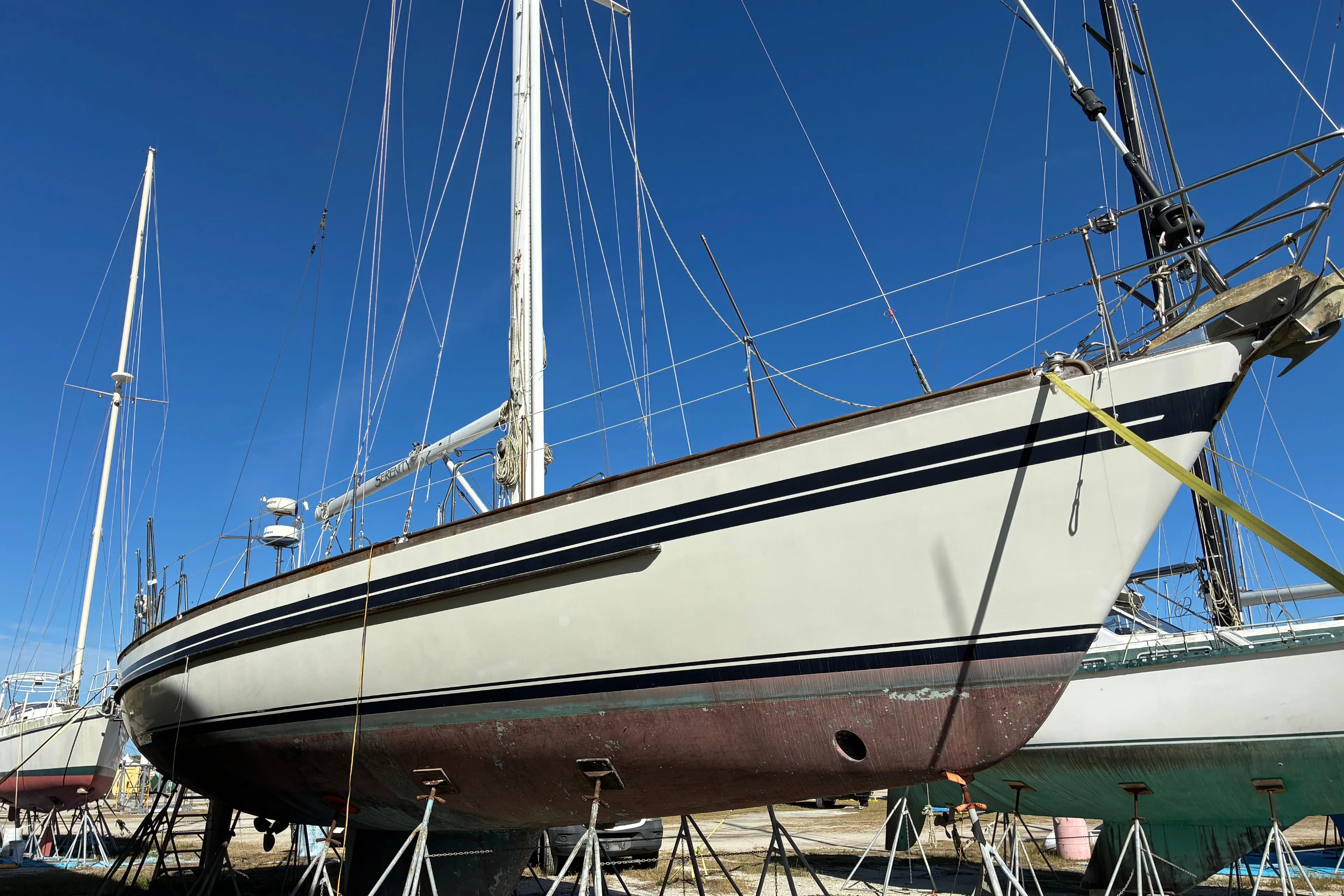 Sailboat Tayana 55, 1998 model, on dry dock under clear blue sky.