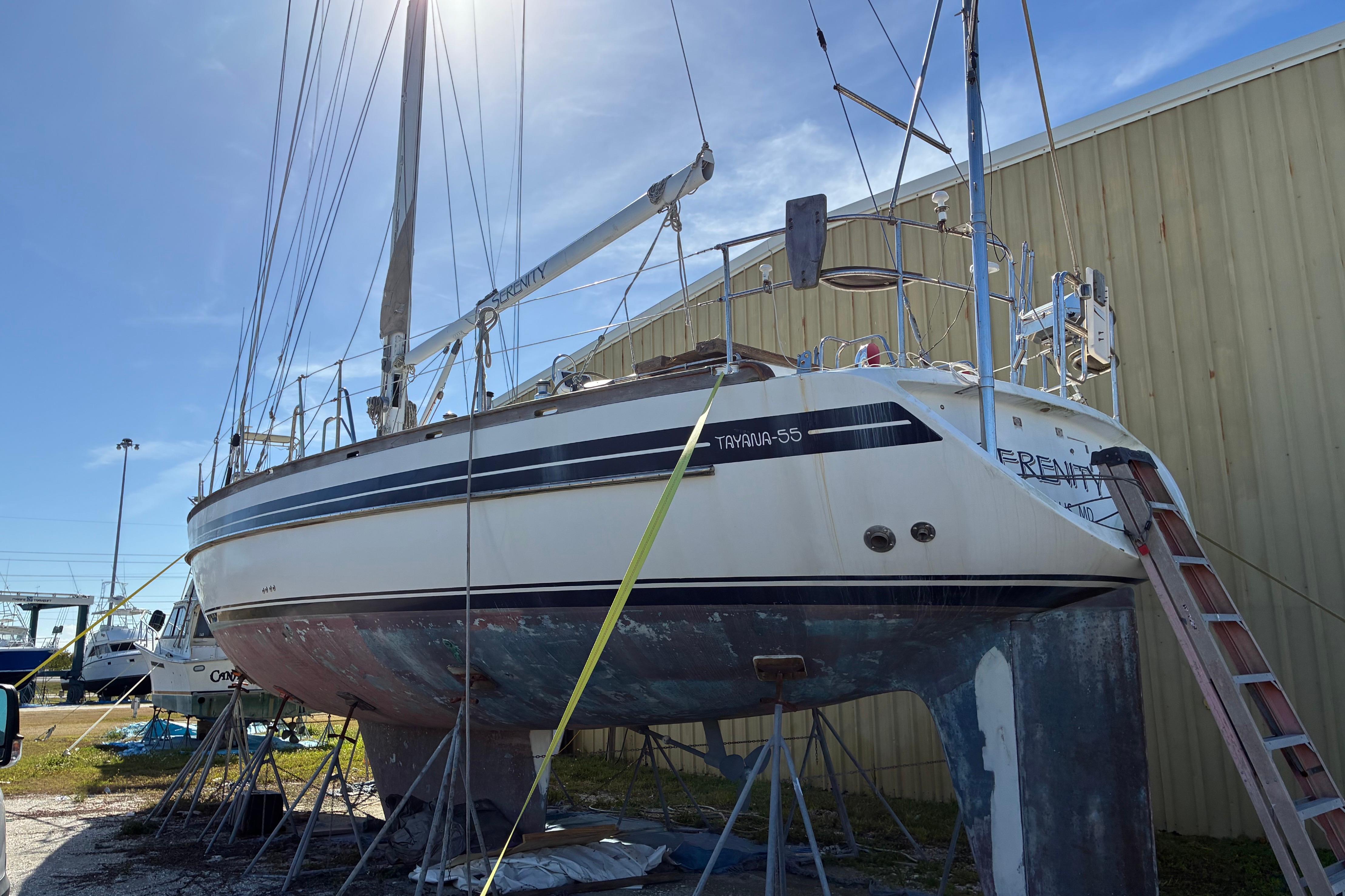 1998 Tayana 55 sailboat on dry dock, undergoing maintenance under clear blue sky.
