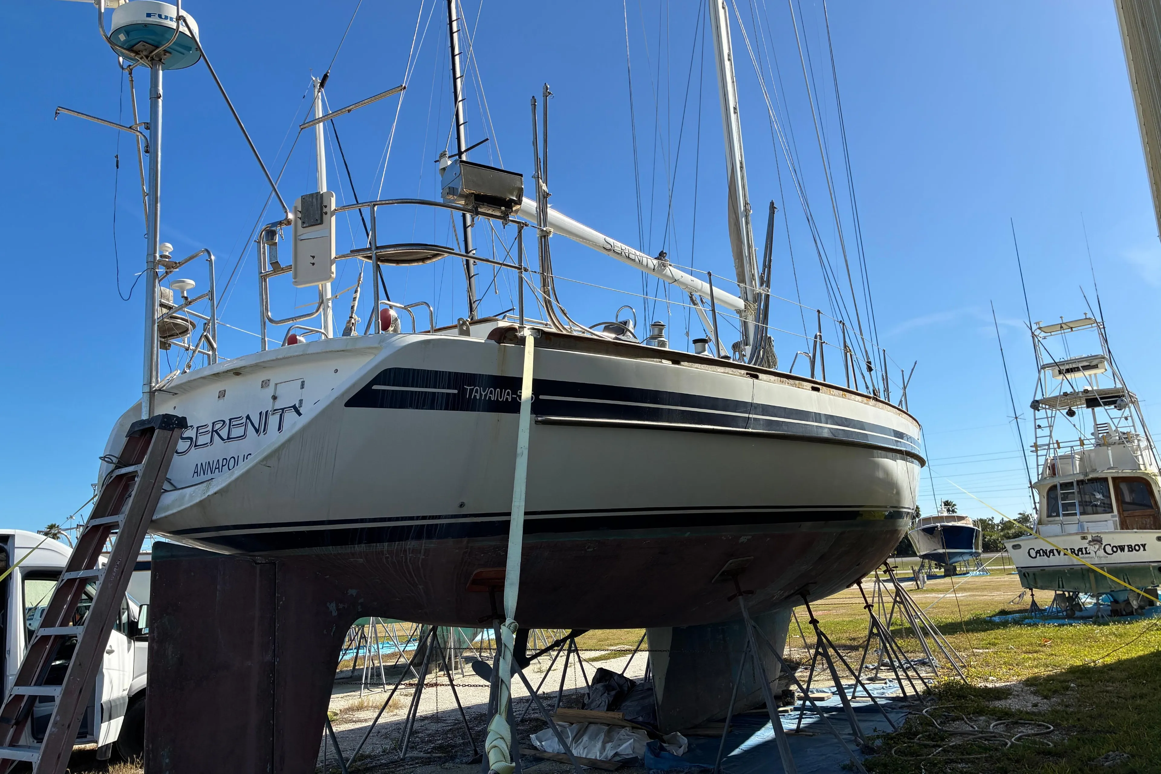 Sailboat Tayana 55, 1998 model, on dry dock under clear blue sky.
