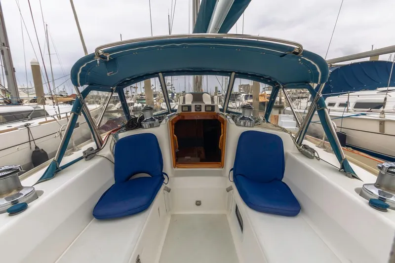 Lark Yacht Photos Pics 2001 J Boats 46 cockpit with blue seating and canopy in marina.