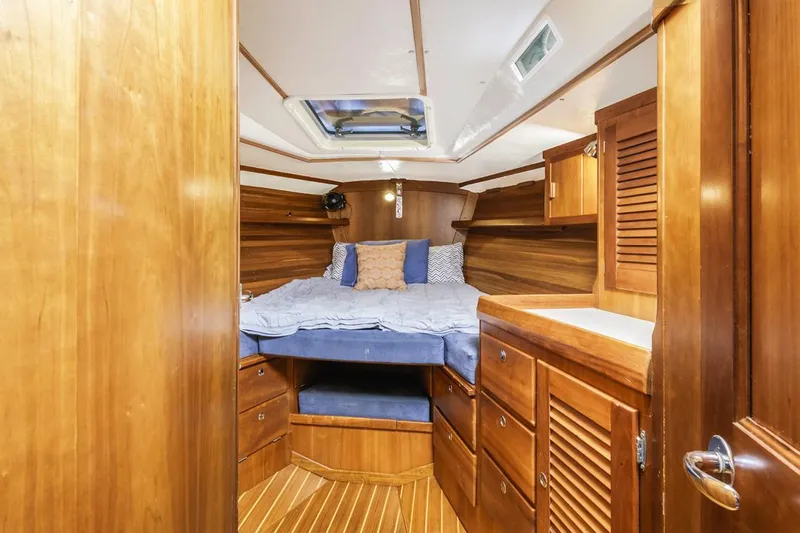 Lark Yacht Photos Pics Cozy cabin interior of 2001 J Boats 46, featuring wooden furnishings and a comfortable bed.