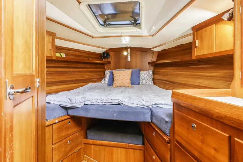 Lark Yacht Photos Pics Cozy cabin interior of 2001 J Boats 46, featuring wooden furnishings and a comfortable bed.