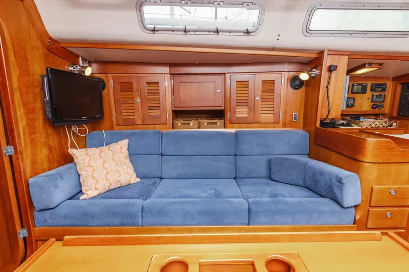 Lark Yacht Photos Pics Luxurious 2001 J Boats 46 interior with blue sofa and wooden cabinetry.