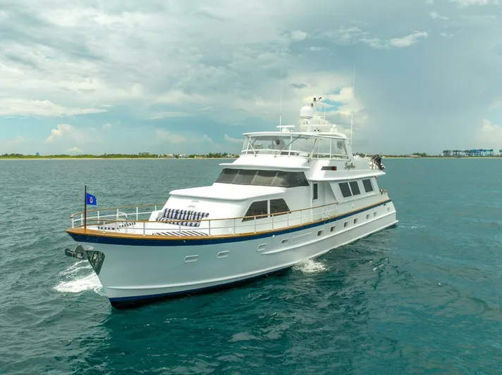 Lady Helen Yacht Photos Pics Elegant 1982 Broward 87 yacht cruising on open water under cloudy skies.