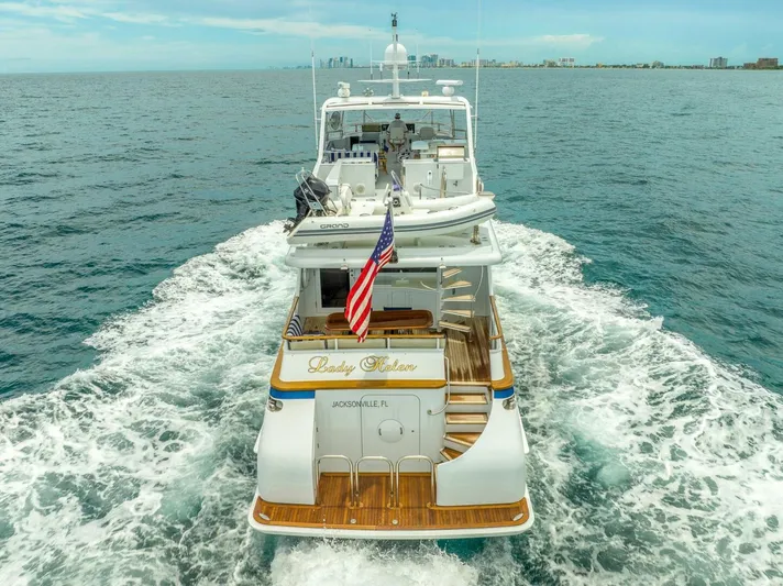Lady Helen Yacht Photos Pics Luxury yacht Broward 87 cruising on open sea, 1982 model, with American flag displayed.