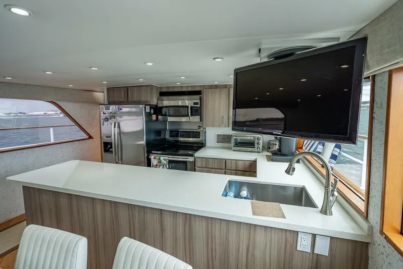 Lady Helen Yacht Photos Pics Modern kitchen interior on 1982 Broward 87 yacht with sleek appliances and large TV.