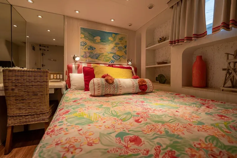Lady Helen Yacht Photos Pics Cozy bedroom in 1982 Broward 87 yacht with colorful bedding and decorative accents.