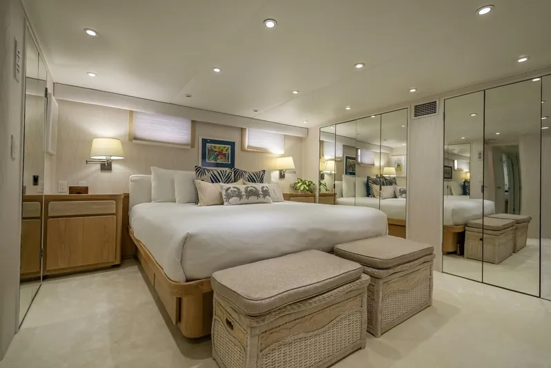 Lady Helen Yacht Photos Pics Luxurious bedroom interior on 1982 Broward 87 yacht with mirrored walls and elegant decor.