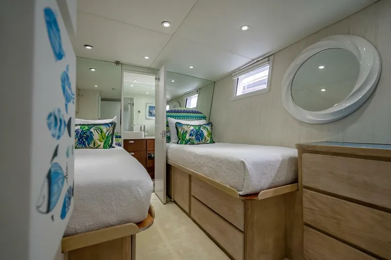 Lady Helen Yacht Photos Pics Luxurious 1982 Broward 87 yacht bedroom with twin beds and modern decor.