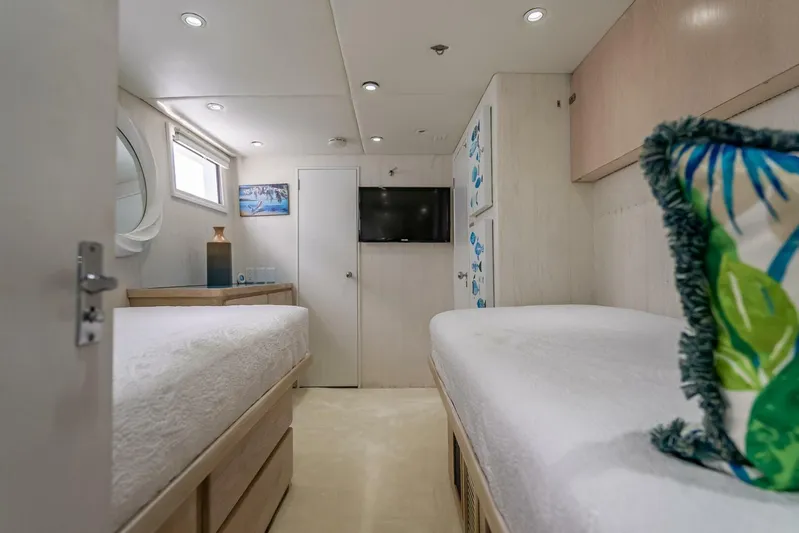 Lady Helen Yacht Photos Pics Interior of 1982 Broward 87 yacht with twin beds, TV, and modern decor.