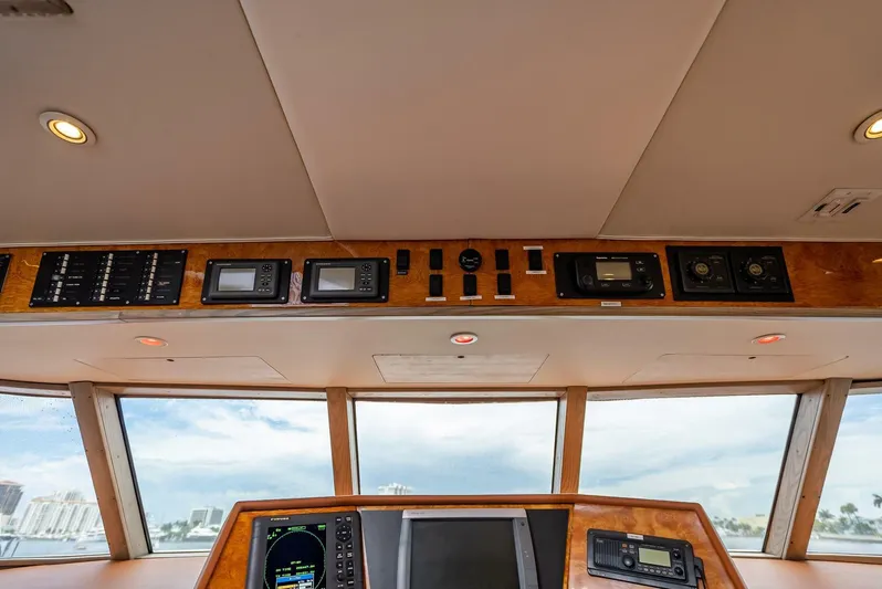 Lady Helen Yacht Photos Pics Control panel of a 1982 Broward 87 yacht with navigation instruments and ocean view.