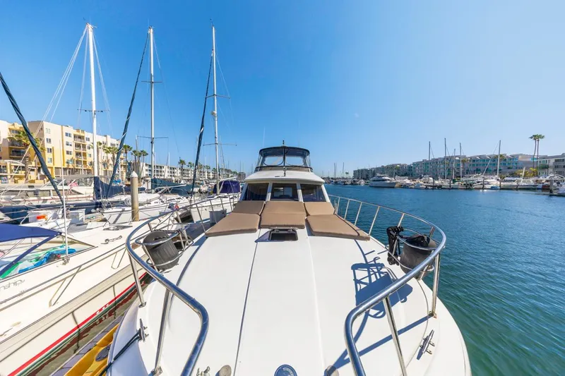 Katerina Yacht Photos Pics 1996 Navigator 5300 Classic yacht docked in a sunny marina, surrounded by sailboats.