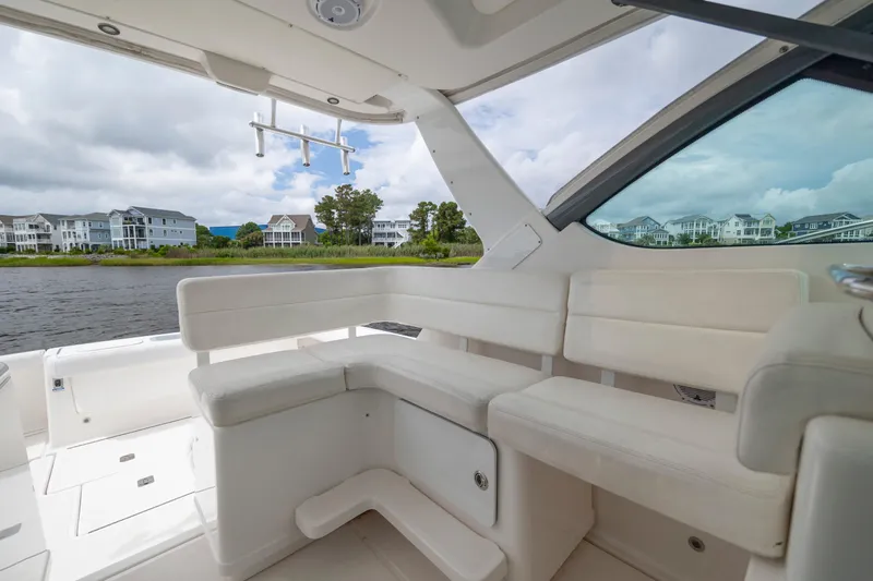 Knot On Call Yacht Photos Pics 2004 Tiara Yachts 3200 Open interior with white seating, overlooking waterfront homes.