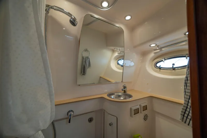 Knot On Call Yacht Photos Pics 2004 Tiara Yachts 3200 Open bathroom with sink, mirror, and porthole window.