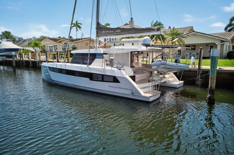Ten-seven Freedom Yacht Photos Pics 2023 Leopard 42 catamaran docked in a residential marina setting.