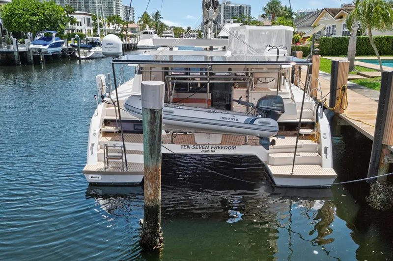 Ten-seven Freedom Yacht Photos Pics 2023 Leopard 42 catamaran docked, featuring a dinghy and modern marina backdrop.