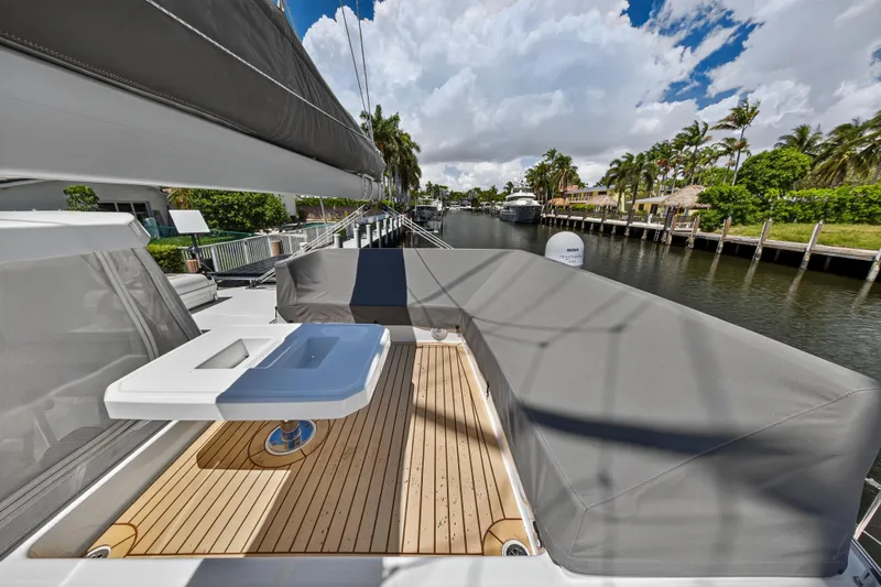 Ten-seven Freedom Yacht Photos Pics Luxury Leopard 42 yacht deck with modern seating, docked by a scenic canal, 2023 model.