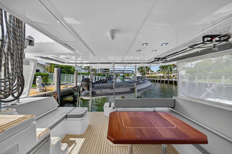 Ten-seven Freedom Yacht Photos Pics Luxurious 2023 Leopard 42 yacht interior with wooden table and waterfront view.