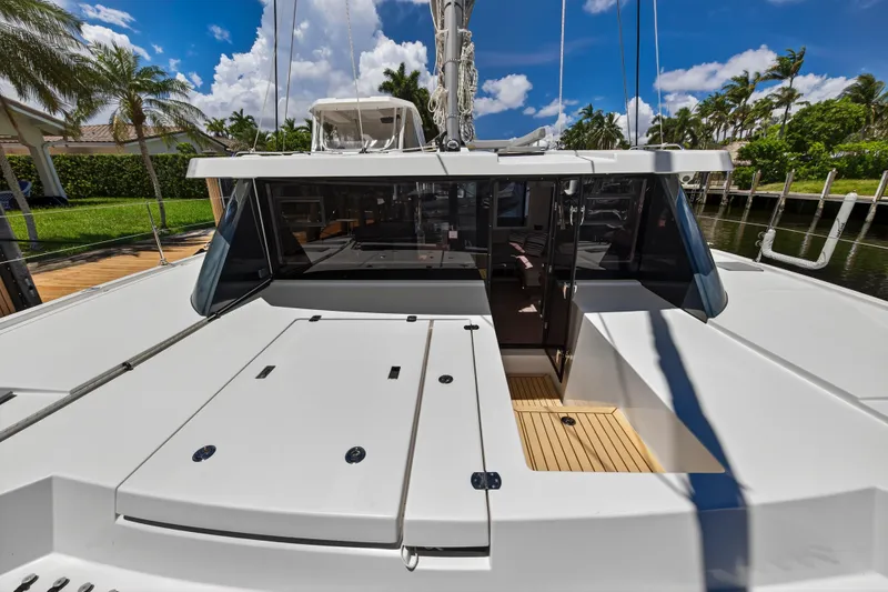 Ten-seven Freedom Yacht Photos Pics 2023 Leopard 42 yacht deck with sleek design, docked near palm trees under blue sky.