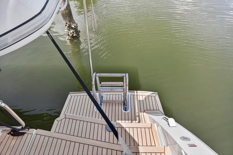 Ten-seven Freedom Yacht Photos Pics Sleek 2023 Leopard 42 yacht swim platform with ladder, docked on calm water.
