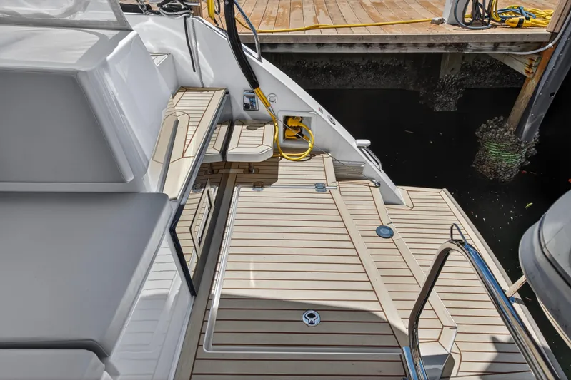 Ten-seven Freedom Yacht Photos Pics Luxury Leopard 42 yacht deck, 2023 model, docked with wooden flooring and seating.