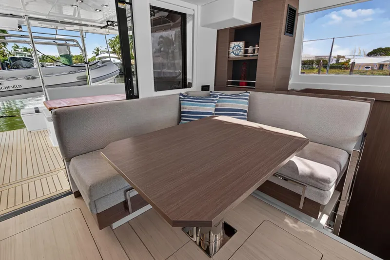 Ten-seven Freedom Yacht Photos Pics Modern interior of 2023 Leopard 42 yacht with cozy seating and wooden table.