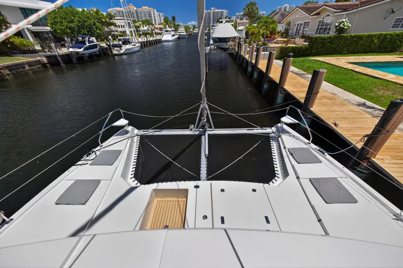 Ten-seven Freedom Yacht Photos Pics 2023 Leopard 42 catamaran docked in a scenic canal with luxury homes.