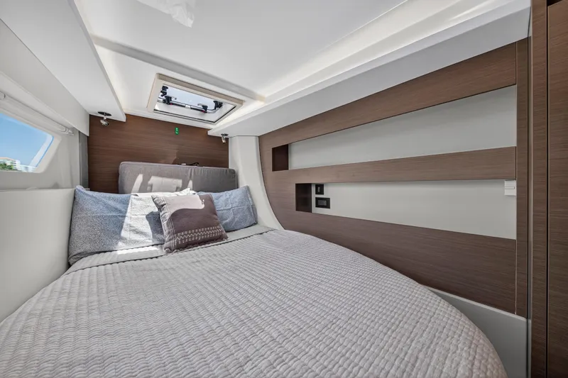 Ten-seven Freedom Yacht Photos Pics Luxurious cabin interior of 2023 Leopard 42 yacht with modern bedding and wood accents.
