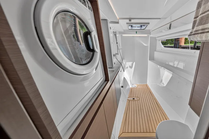 Ten-seven Freedom Yacht Photos Pics Modern yacht bathroom with washer, wooden flooring, and skylight in 2023 Leopard 42 model.