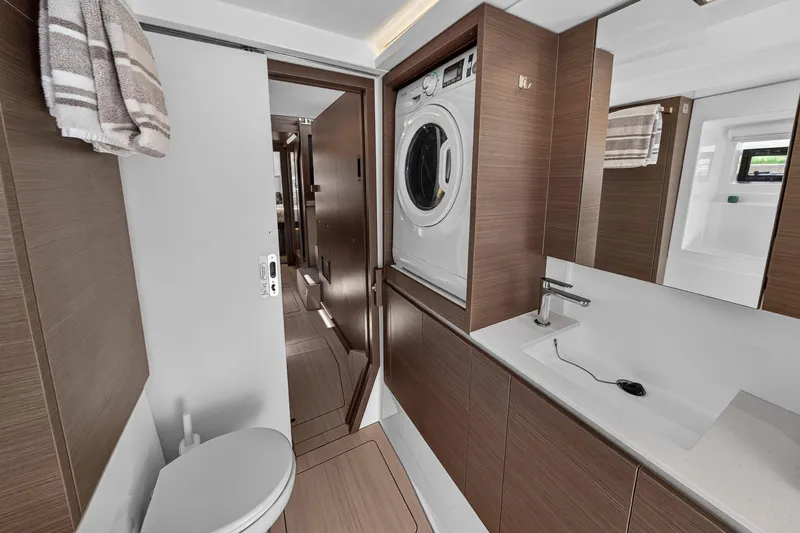 Ten-seven Freedom Yacht Photos Pics Modern bathroom in 2023 Leopard 42 yacht with washer-dryer, sink, and toilet.