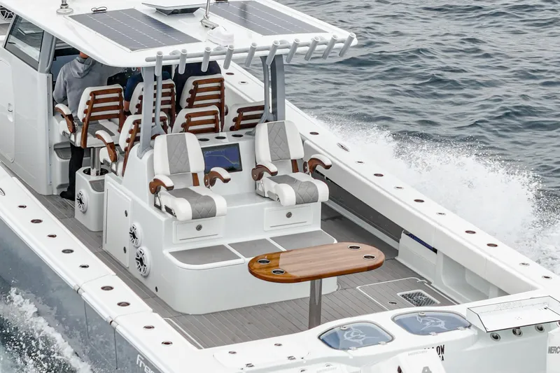  Yacht Photos Pics 2024 Freeman 47 boat with sleek seating and table, cruising on open water.