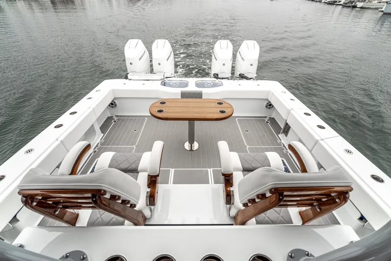  Yacht Photos Pics 2024 Freeman 47 boat deck with seating, table, and four outboard engines on water.