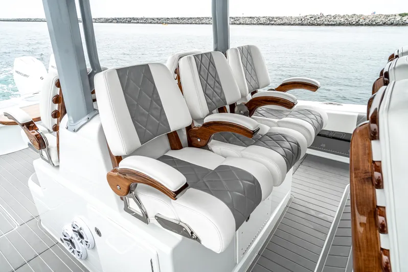  Yacht Photos Pics Luxurious seating on 2024 Freeman 47 boat with quilted upholstery and wooden armrests.