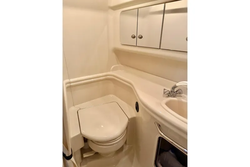  Yacht Photos Pics Compact bathroom in 2006 Sea Ray 340 Sundancer yacht, featuring toilet, sink, and storage cabinets.