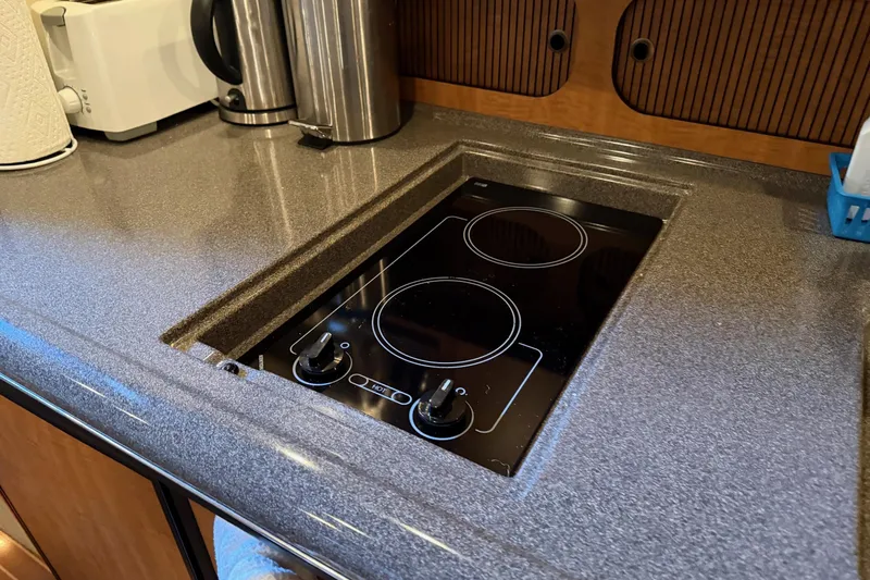  Yacht Photos Pics Modern kitchen area in a 2006 Sea Ray 340 Sundancer yacht with electric stovetop.