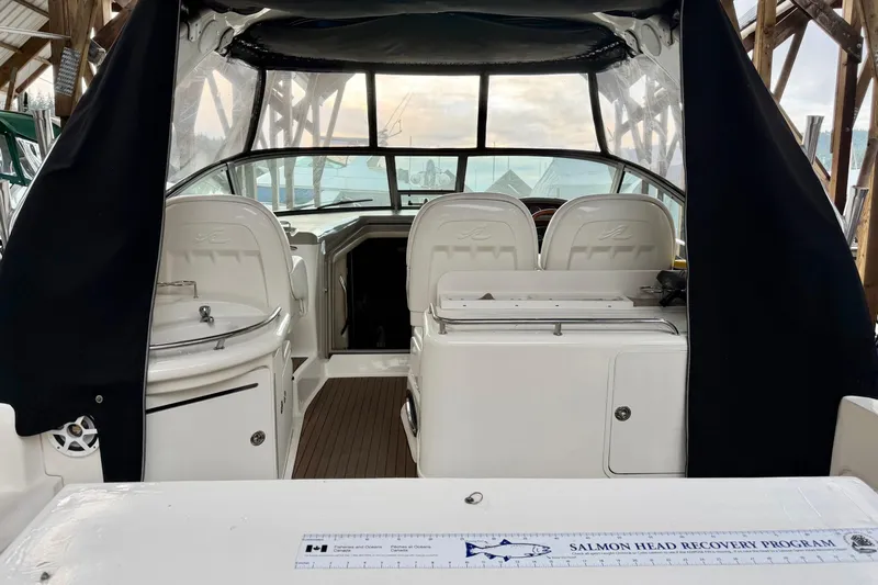  Yacht Photos Pics 2006 Sea Ray 340 Sundancer boat interior with seating and helm, docked under cover.