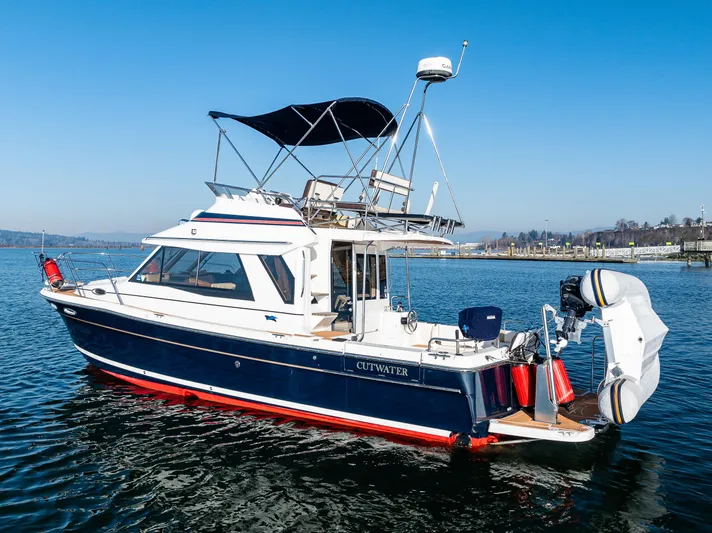 Awol Yacht Photos Pics 2016 Cutwater 30 Command Bridge boat on calm water, featuring a sleek design and canopy.